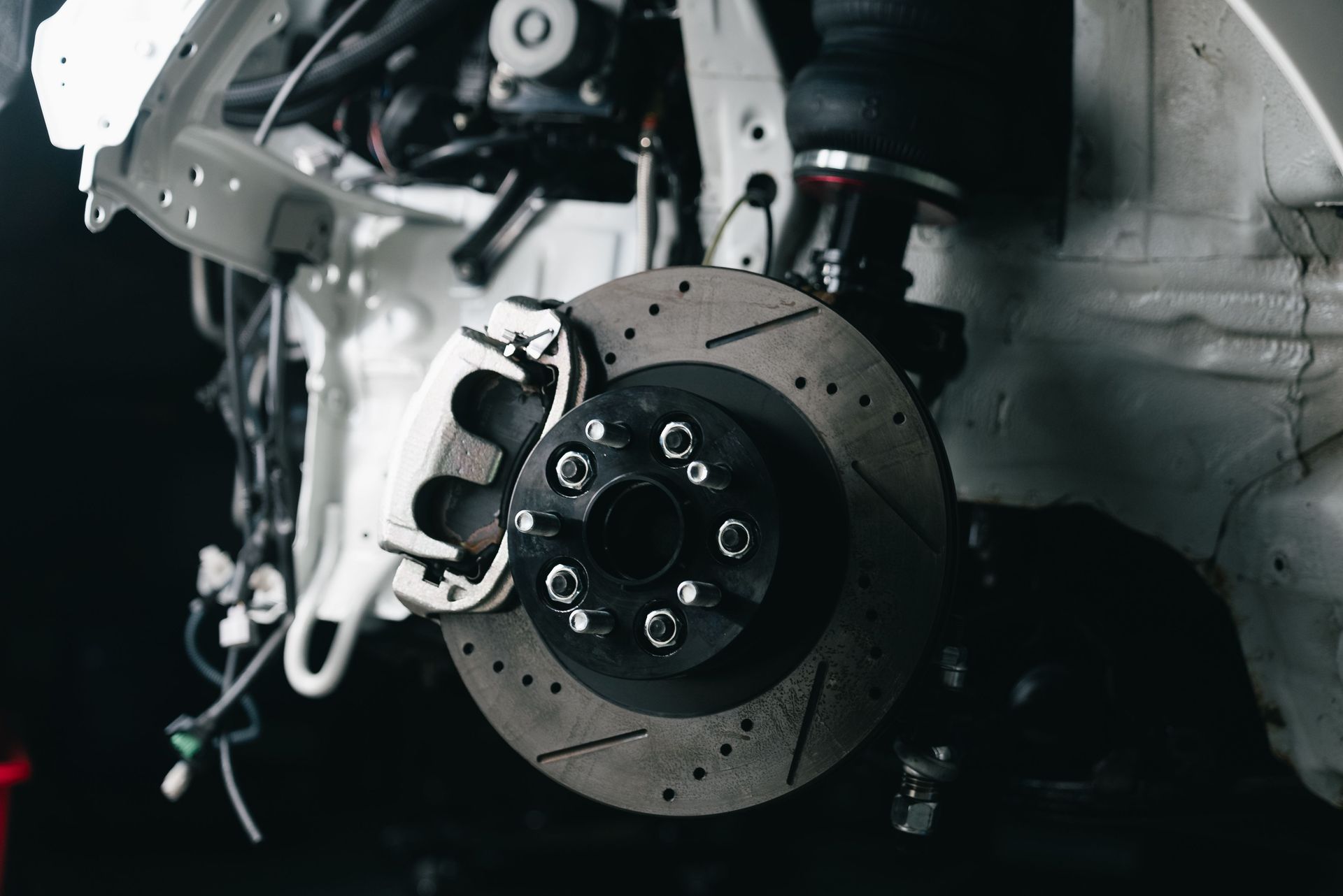 Detailed view of a vehicle's disc brake system with caliper, showcasing automotive technology.
